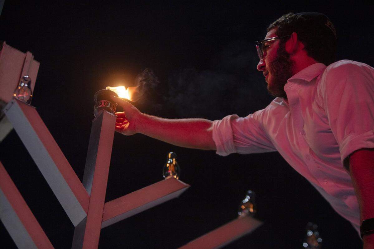 Yossi Spivak, 17, lights the first candle during a grand menorah lighting marking the first night of Hanukkah on Lincoln Road, Dec. 14, 2025, in Miami Beach, Fla. The menorah lighting and Hanukkah festival marked the start of the holiday.