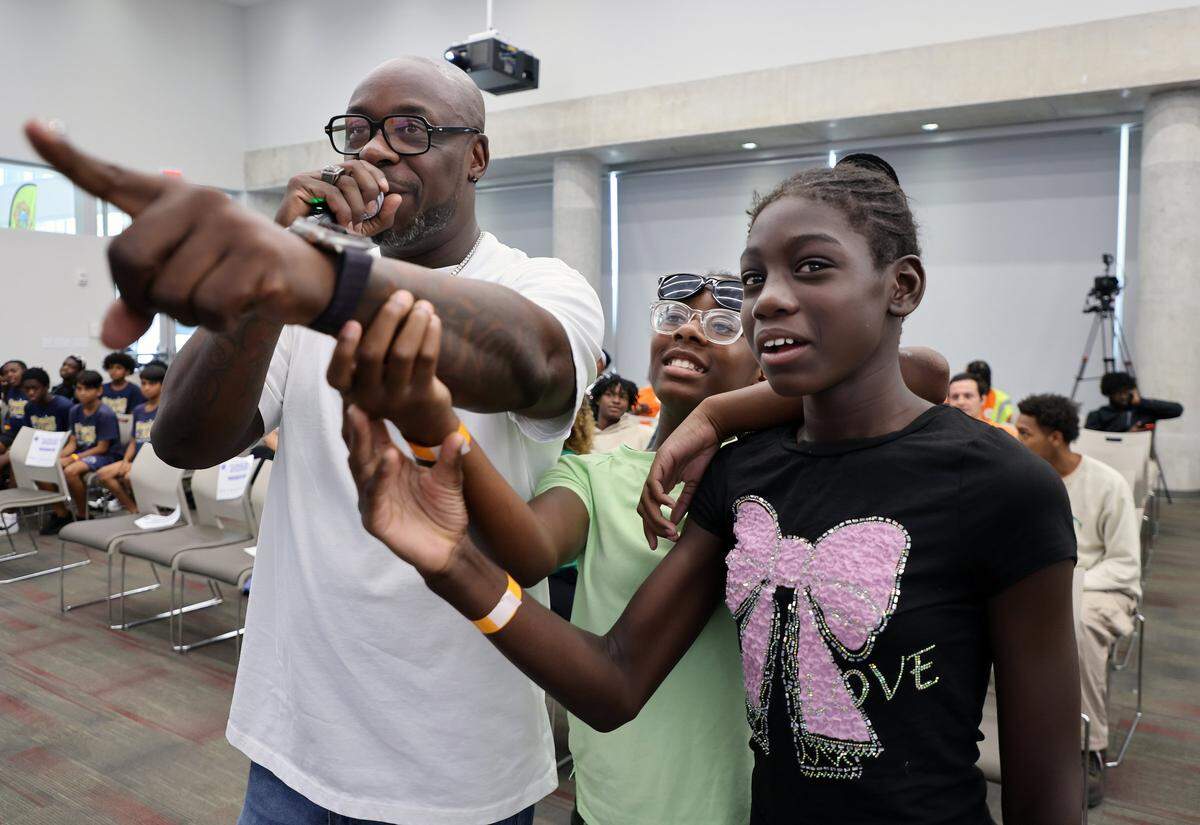 BEAT 103 radio personality, Keith “Papa Keith” Walcott, left, gets help with judging the dance contest from Jaylah Castro, 10, center, and Elizabeth Carter, 11, right, during the Amplify Community Resources’ 4th Annual Back-to-School Youth Readiness Summit.