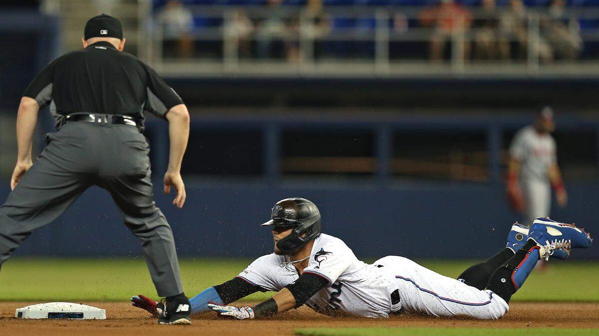 Miami Marlins shortstop Miguel Rojas (19) slides into second base after hitting a double during the first inning of an Major League Baseball game against the Washington Nationals at Marlins Park in Miami on Thursday, June 27, 2019.