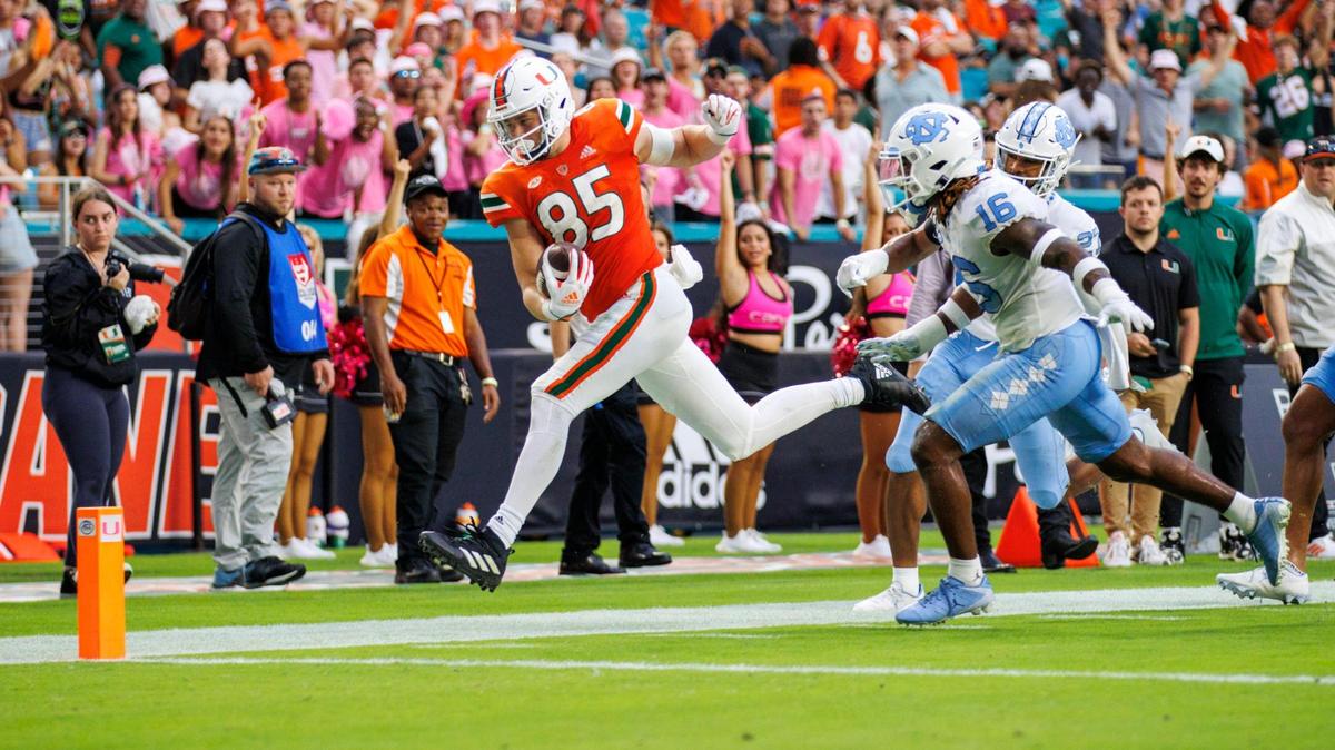 Miami Hurricanes tight end Will Mallory (85) runs with the football against North Carolina Tar Heels defensive back DeAndre Boykins (16) during the second quarter of an ACC conference football game at Hard Rock Stadium on Saturday, October 8, 2022 in Miami Gardens, Florida..