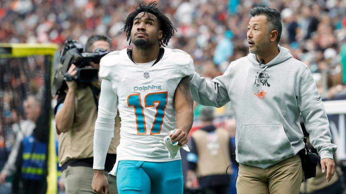 An injured Miami Dolphins wide receiver Jaylen Waddle (17) is escorted off the field during the first half of the NFL game against the Houston Texans at NRG Stadium in Houston, Texas, on Sunday, December 15, 2024.