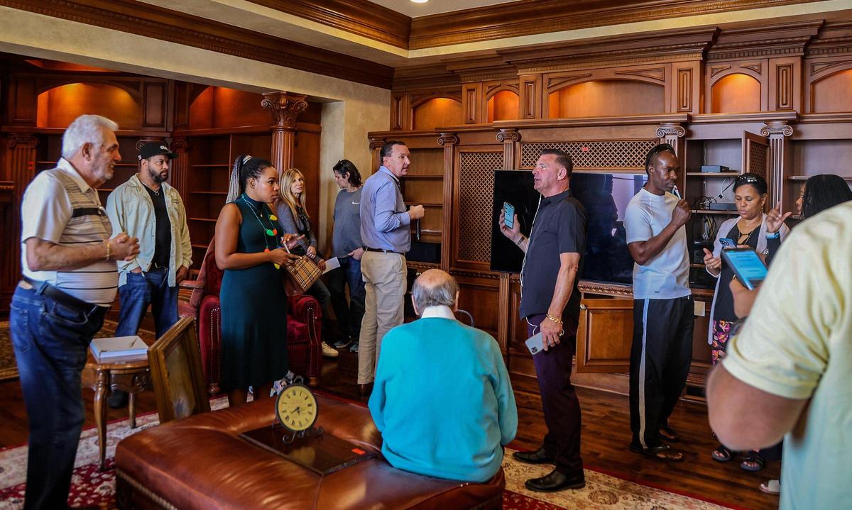 Attorney Kaysia M. Earley (center left) was among a group of people that attended an auction hosted by Scott Grasso (in black) and George Farley (blue shirt center) with Auctions4America to buy piece of La Maison Blanche —the White House — a 1930s neoclassical estate on the Intracoastal from a 1-acre plot of land, in Fort Lauderdale, that will be demolished in a couple weeks, and will be replaced by a 20,000-square-foot modernist home, on, Saturday Dec. 23, 2023.