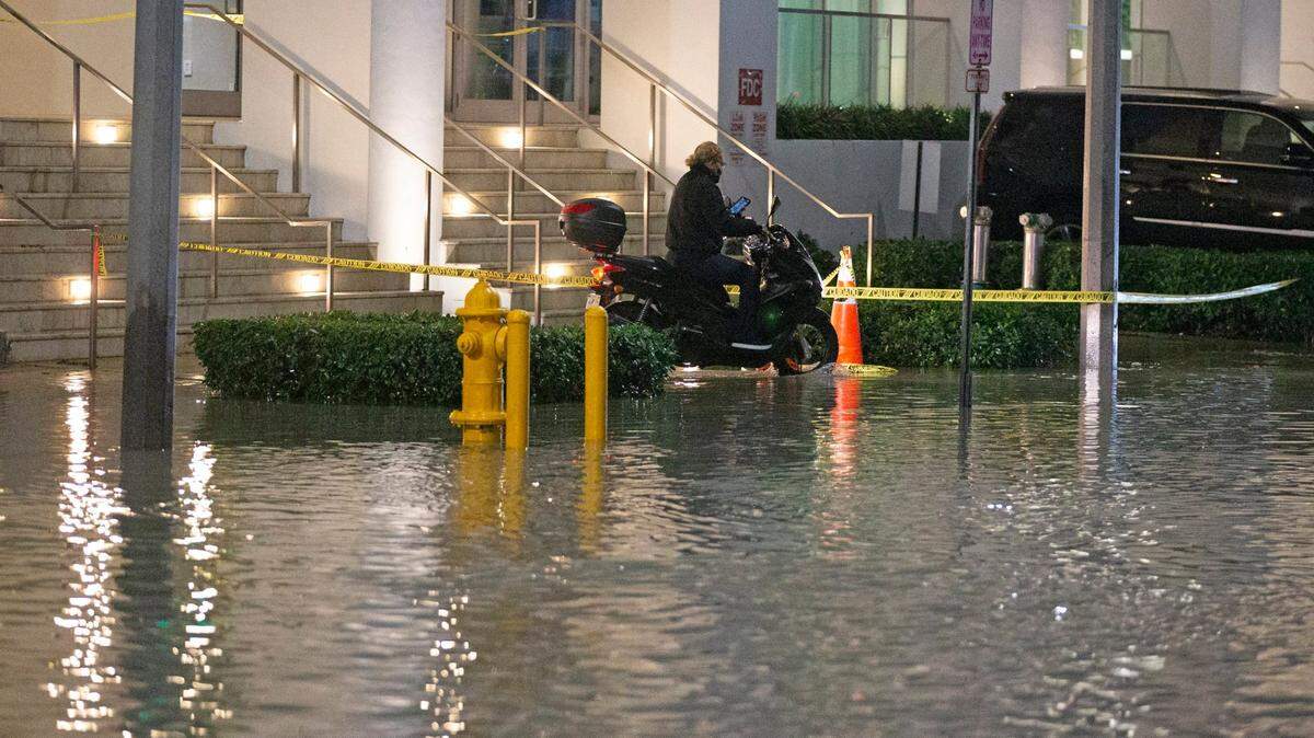 A motorcyclist navigates around a flooded Northeast 11th Street and Biscayne Boulevard in downtown Miami on Tuesday, Feb. 16, 2021.