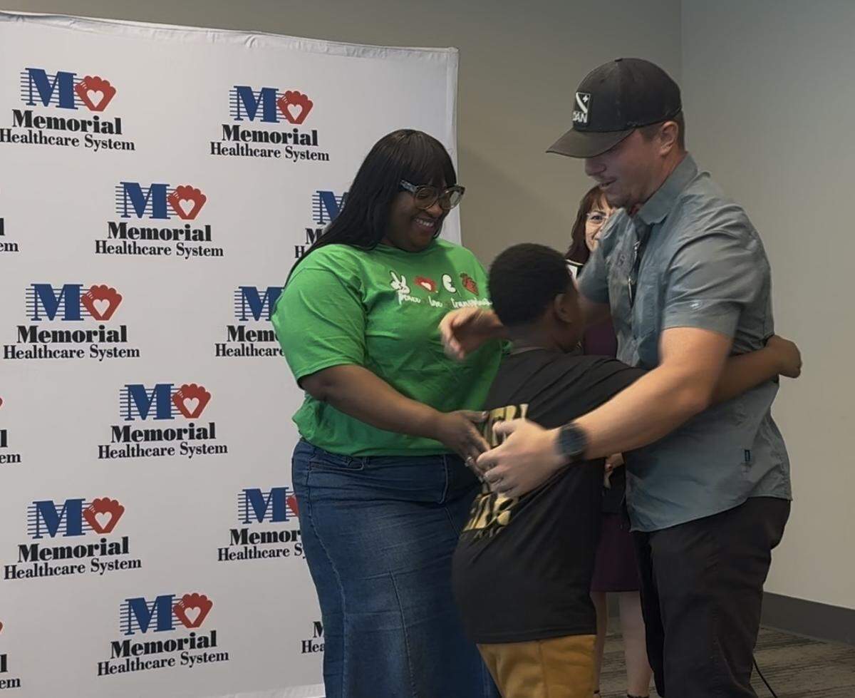 Ferline Lamothe and her son Aaron, 9, hug his living kidney donor, Nick “Cuda” Kolor, during a reunion at Memorial Regional Hospital in Hollywood, Florida, on Monday, Dec. 15, 2025.