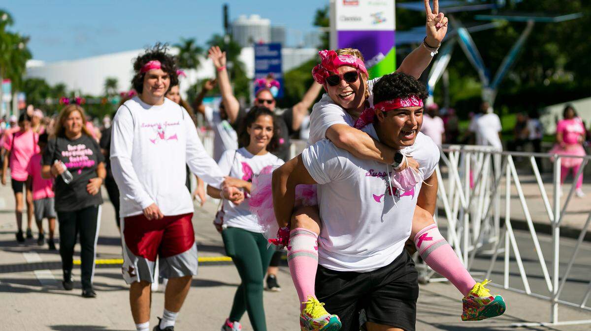 Daniel Noya, 18, carries his mom Noga Nietzen across the finish line during the Susan G. Komen More Than Pink Walk in downtown Miami on Saturday, October 16, 2021. The event aims to raise awareness and money for breast cancer research. Nietzen, who works at Baptist Hospital, is a 1-year breast cancer survivor.