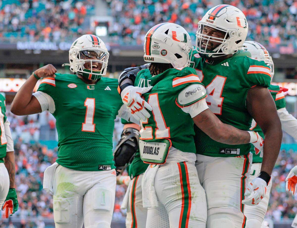 Miami Hurricanes running back Jordan Lyle (21) celehis touchdown with quarterback Cam Ward (1) and Miami Hurricanes offensive lineman Jalen Rivers (64) against the Wake Forest Demon Deacons in the second half of their NCAA game in Miami Gardens, Florida, on Saturday, November 23, 2024.