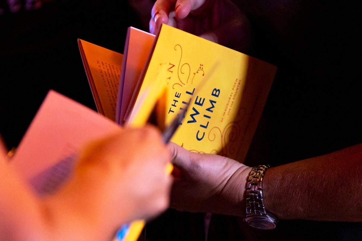 A concertgoer holds a copy of “The Hill We Climb” by Amanda Gorman. Earlier this year, the Bob Graham Education Center in Miami Lakes, a K-8 public school, restricted elementary school students from access the book after a parent objected to it, along with four other titles, claiming they included topics that were inappropriate for students and should be removed ‘from the total environment.’