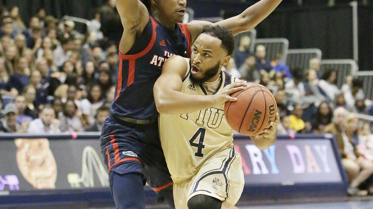 FIU Panthers’ Brian Beard Jr. (4) slides around FAU Owls’ plyer during the men’s basketball game on Jan. at FIU Ocean Bank Convocation Center in Miami