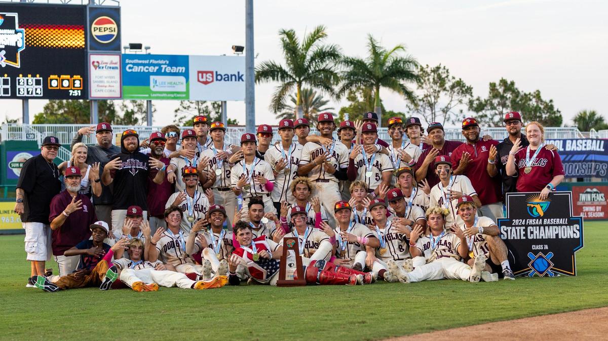 Marjory Stoneman Douglas players and coaches pose with the trophy after a walk-off single to defeat Windermere 3-2 in extra innings for the Class 7A state baseball championship game at Hammond Stadium on Saturday, May 18, 2024, in Fort Myers, Fla.