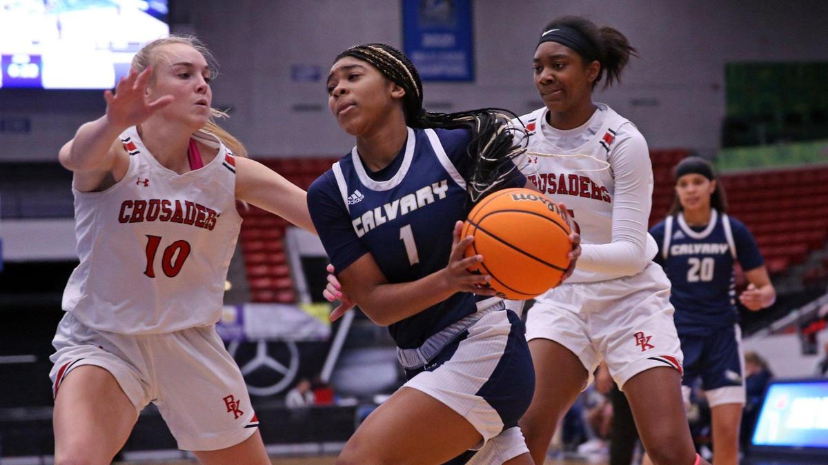 Calvary Christian’s Samiyah Briggs (1) drives towards the basket as Bishop Kenny’s Maddie Millar (10) defends in a girls’ basketball Class 4A state semifinal. at the RP Funding Center in Lakeland on Thursday, February 24, 2022.