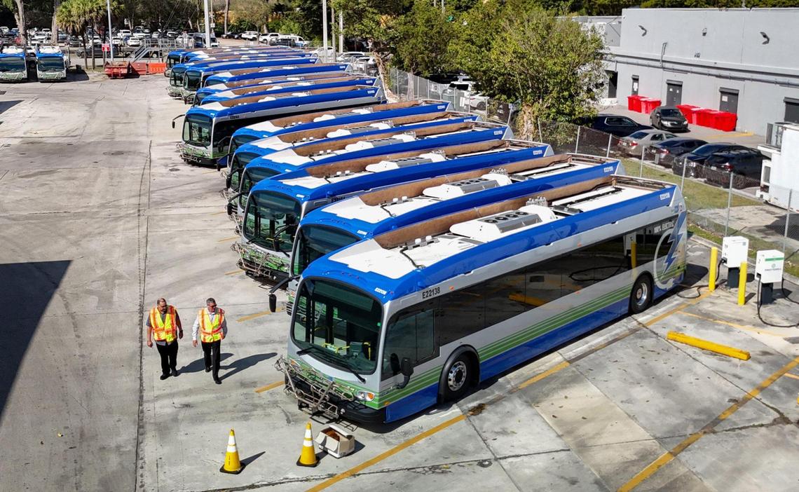 Lazaro Dominguez, with the Department of Transportation and Public Works and Felipe Hermida, Section Chief of Bus Operations, seen left to right, walk past broken electric Proterra buses parked at Miami-Dade County Coral Way Bus Maintenance Facility in Miami on Wednesday, February 19, 2025.