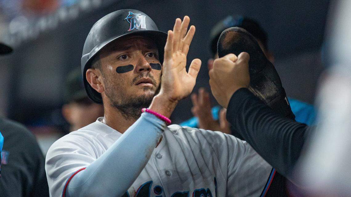 Miami Marlins shortstop Miguel Rojas (11) is congratulated by teammates after scoring on sacrifice fly by Lewin Diaz during the second inning of an MLB game against the San Diego Padres at loanDepot park in Miami, Florida, on Monday, Aug. 15, 2022.