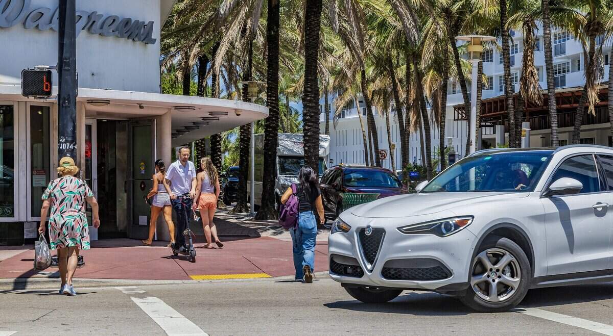 A car passes as pedestrians crosses the street intersection at Lincoln Road and Collins Avenue, a hotspot where pedestrians get hit and seriously injured or killed, on Thursday June 11, 2026.