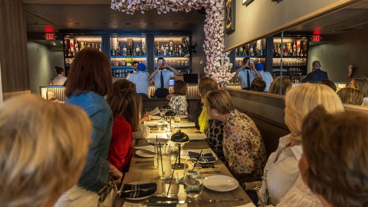 A waiter takes pictures of patrons during lunch time at Casa Vialetto Italian restaurant, recently opened by restauranteur Marcelo Chopa, in Coral Gables after closing Caffe Vialetto, (he co-owned) last summer, on Tuesday June 09, 2026.