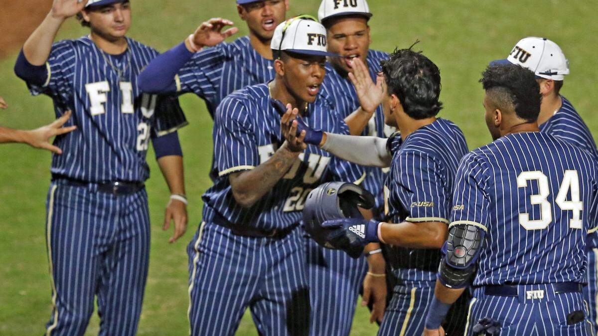 Florida International University’s third baseman Austin Shenton (6) is greeted by teammates after hitting a home run in third inning as FIU hosts the University of Miami at FIU Baseball Stadium on Wednesday, February 27, 2019.