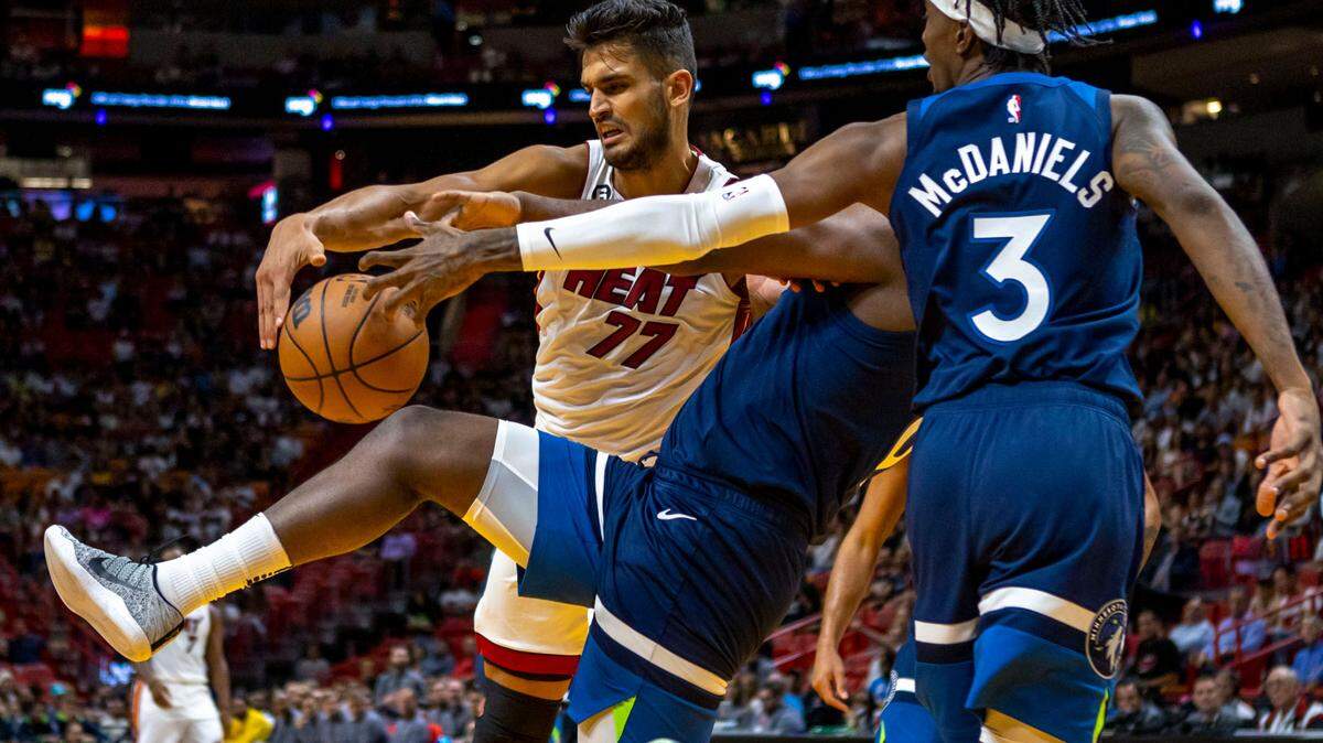 Miami Heat center Omer Yurtseven (77) fights for the rebound with Minnesota Timberwolves defenders Taurean Prince (12) and Jaden McDaniels (3) during the first half of an NBA preseason basketball game at FTX Arena in Miami, Florida, on Tuesday, October 4, 2022.