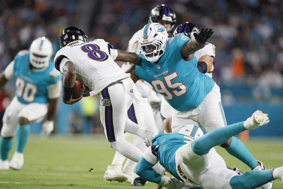Miami Dolphins defensive tackle Benito Jones (95) sacks Baltimore Ravens quarterback Lamar Jackson (8) during the first half of an NFL football game at Hard Rock Stadium on Thursday, October 30, 2025, in Miami Gardens, Florida.