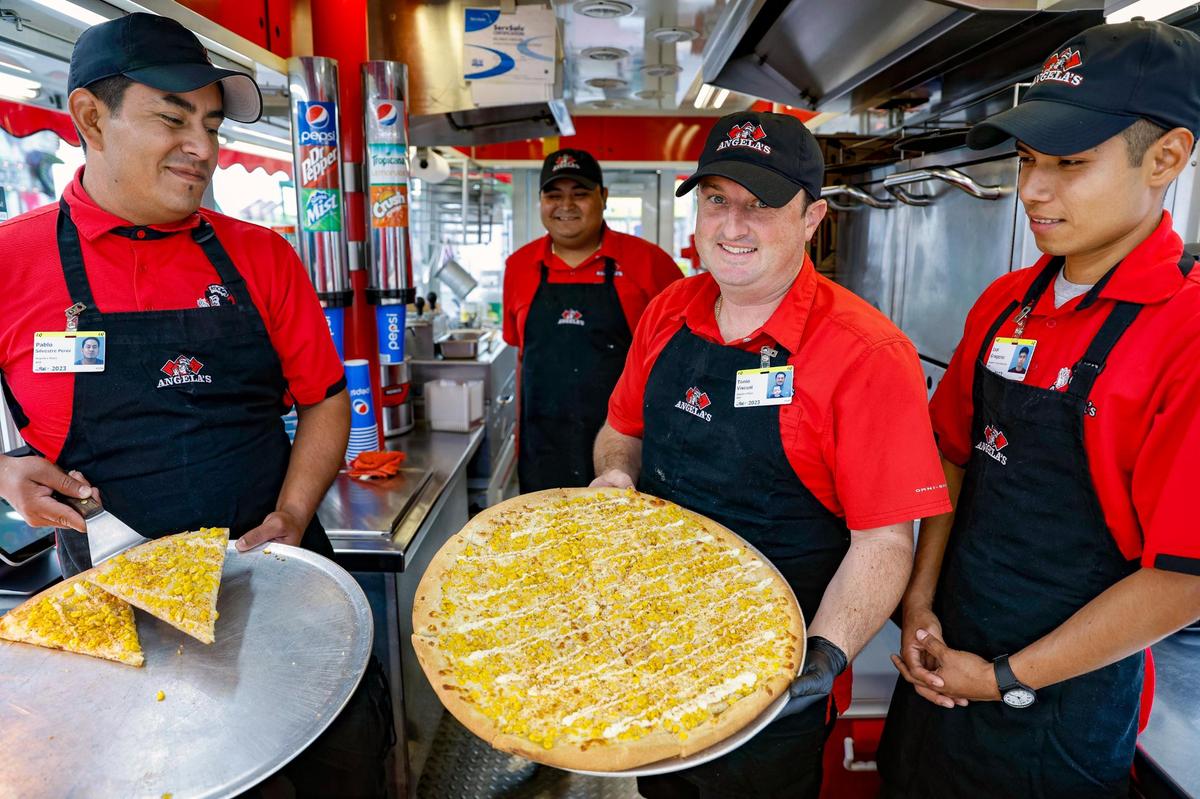 Tonio Viscusi, center, and his staff serve Mexican street corn pizza at the Miami-Dade County Fair & Exposition.