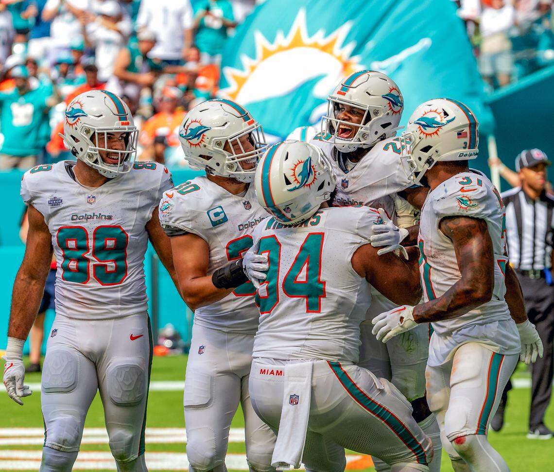 Miami Dolphins running back De’Von Achane (28) celebrates with teammates Julian Hill (89) Alec Ingold (30) Christian Wilkins (94) and Raheem Mostert (31) after scoring a touchdown against the Denver Broncos during fourth quarter of an NFL football game at Hard Rock Stadium on Sunday, Sept. 24, 2023 in Miami Gardens, Fl.