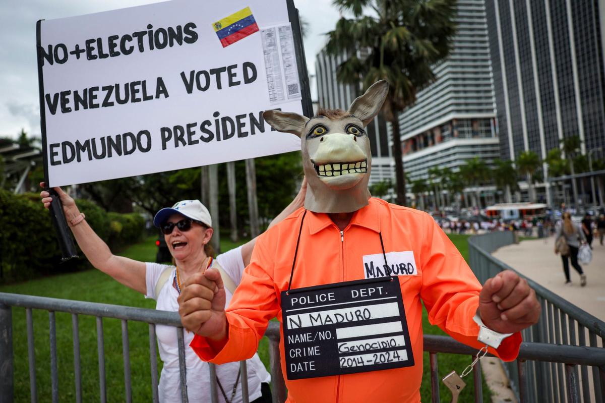 Dressed as a donkey to represent Nicolas Maduro, José Jimenez arrives at a rally at Bayfront Park along with Morela Aguerrevere, left, in downtown Miami, Fla. The rally was held in opposition of Venezuelan strongman Nicolás Maduro and what many in the international community believe was a rigged election.