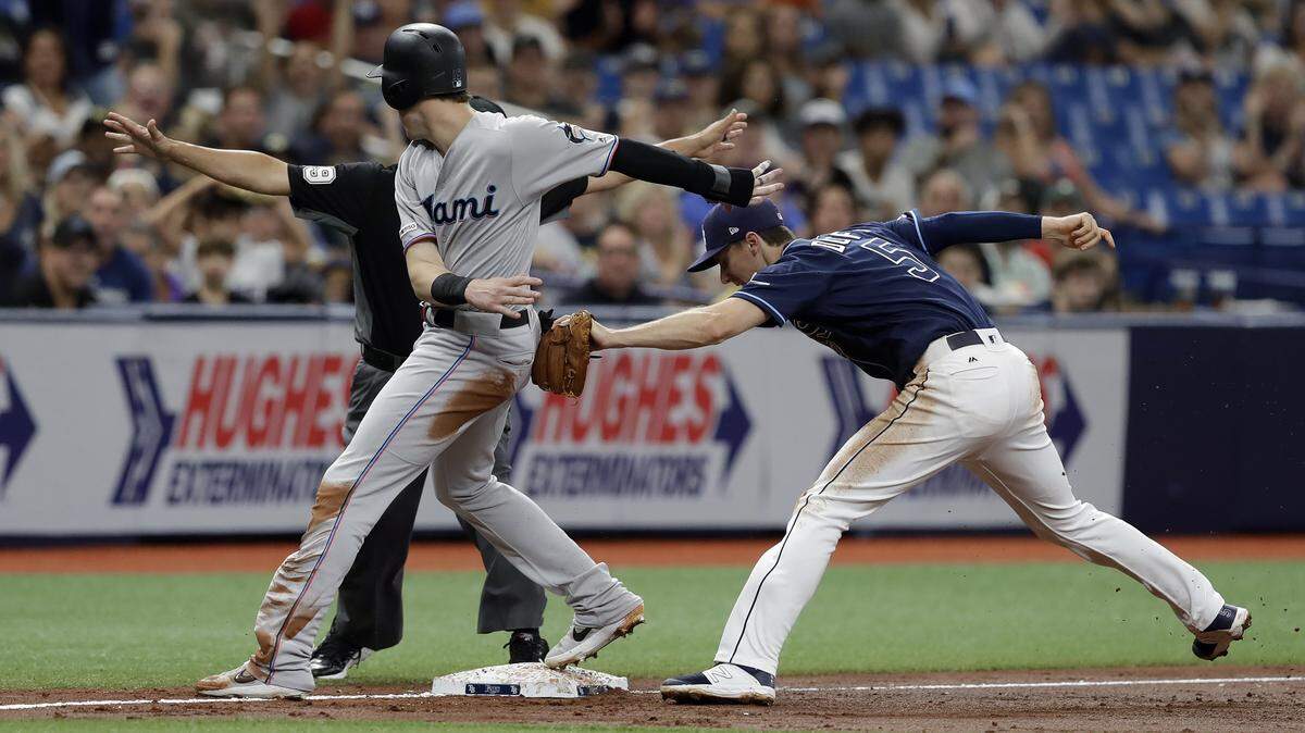 Miami Marlins’ Brian Anderson gets tagged out by Tampa Bay Rays third baseman Matt Duffy, right, after attempting to advance on a flyout by Garrett Cooper during the third inning of a baseball game Saturday, Aug. 3, 2019, in St. Petersburg, Fla.