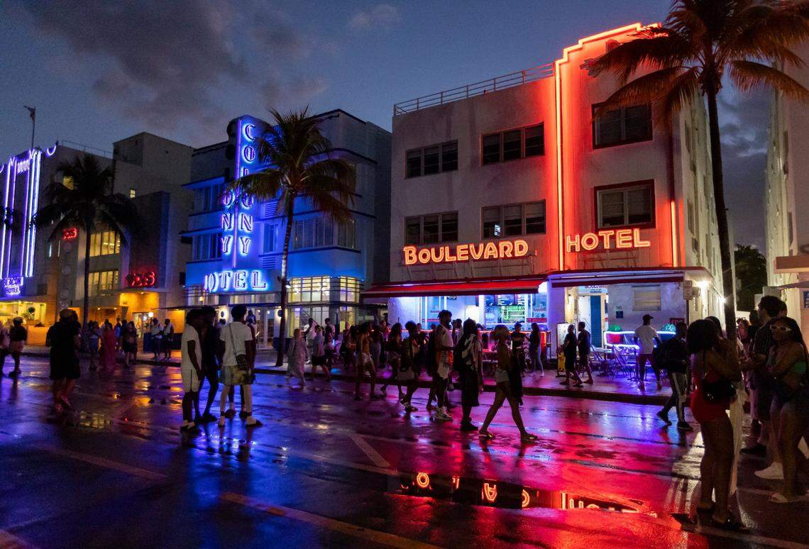 People walk along Ocean Drive during spring break on Saturday, March 11, 2023, in Miami Beach. Bars north of Fifth Street aren’t affected by new alcohol law.