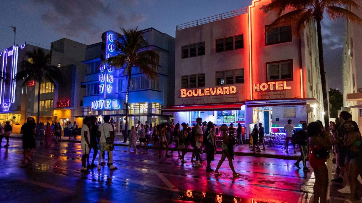 People walk along Ocean Drive during spring break on Saturday, March 11, 2023, in Miami Beach.