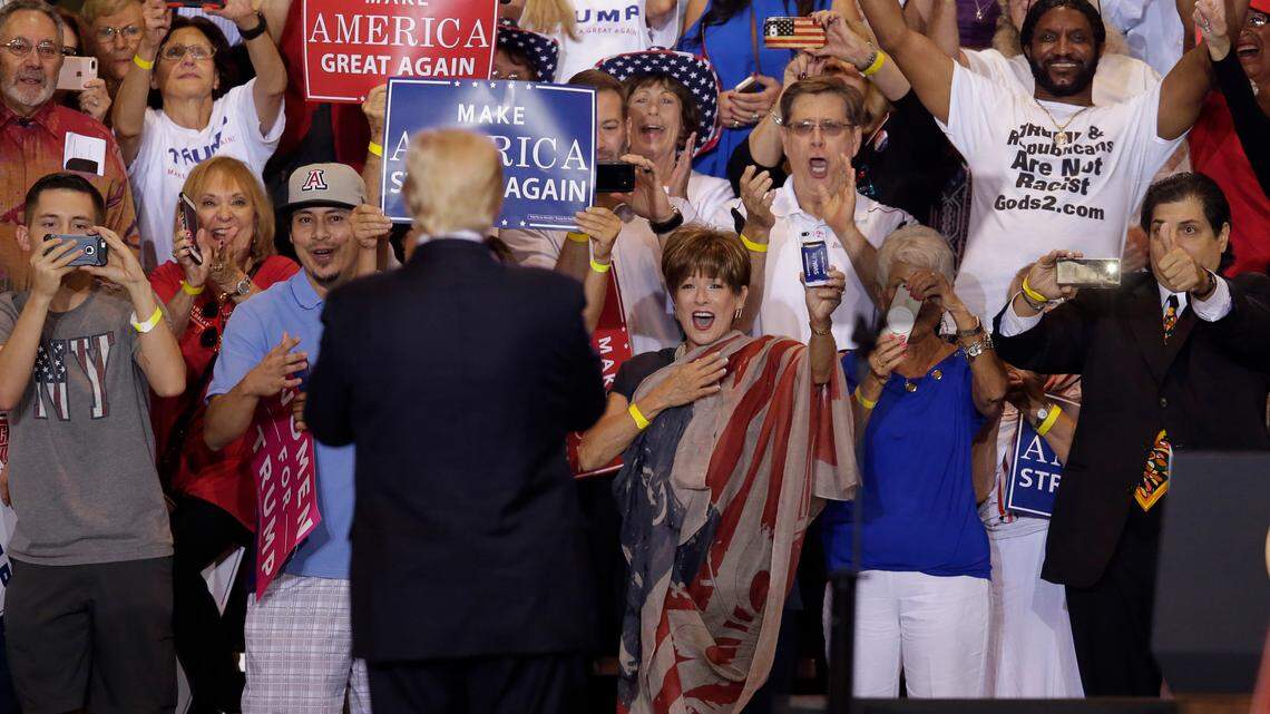 Maurice Symonette, the Black man in the right side of the photo, is seen here in a crowd of Donald Trump supporters at a Phoenix rally in 2017. The founder of ‘Blacks for Trump,’ he also is the president of a ministry that owns a Miami-area home where a man was killed Sunday night. In this photo he’s wearing a shirt that says “Trump & Republicans are not Racist.”