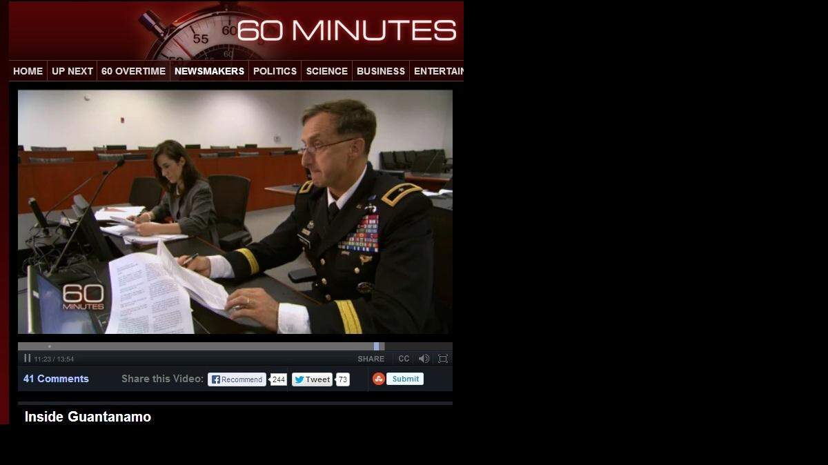 The chief Guantanamo war crimes prosecutor, Army Brig. Gen. Mark Martins, and an aide pose for a CBS crew inside the war court built for the conspiracy trial of accused 9/11 mastermind Khalid Sheik Mohammed during a September visit, in this screen grab from a "60 Minutes" episode that aired Nov. 3, 2013.