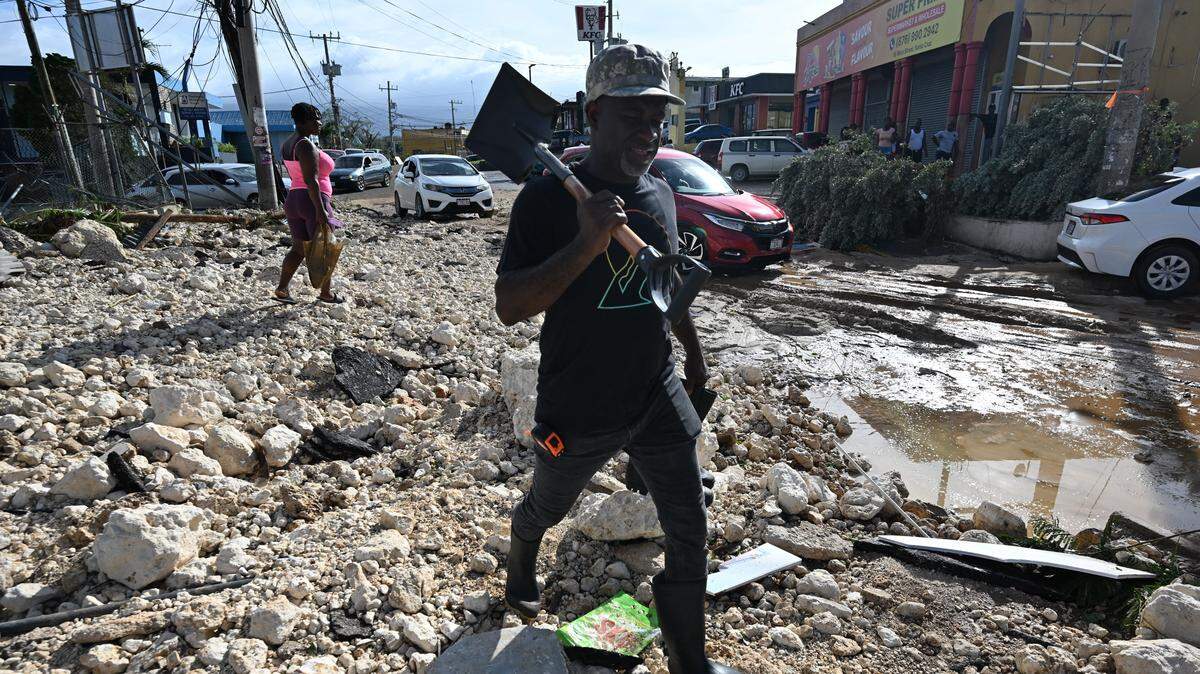 A man walks with a shovel in hand over rubble on Main Street in Santa Cruz, St. Elizabeth, Jamaica on Oct. 29, 2025. Hurricane Melissa ripped up trees and knocked out power after making landfall in Jamaica on Oct. 28, 2025, as one of the most powerful hurricanes on record, inundating the island nation with rains that threaten flash floods and landslides.