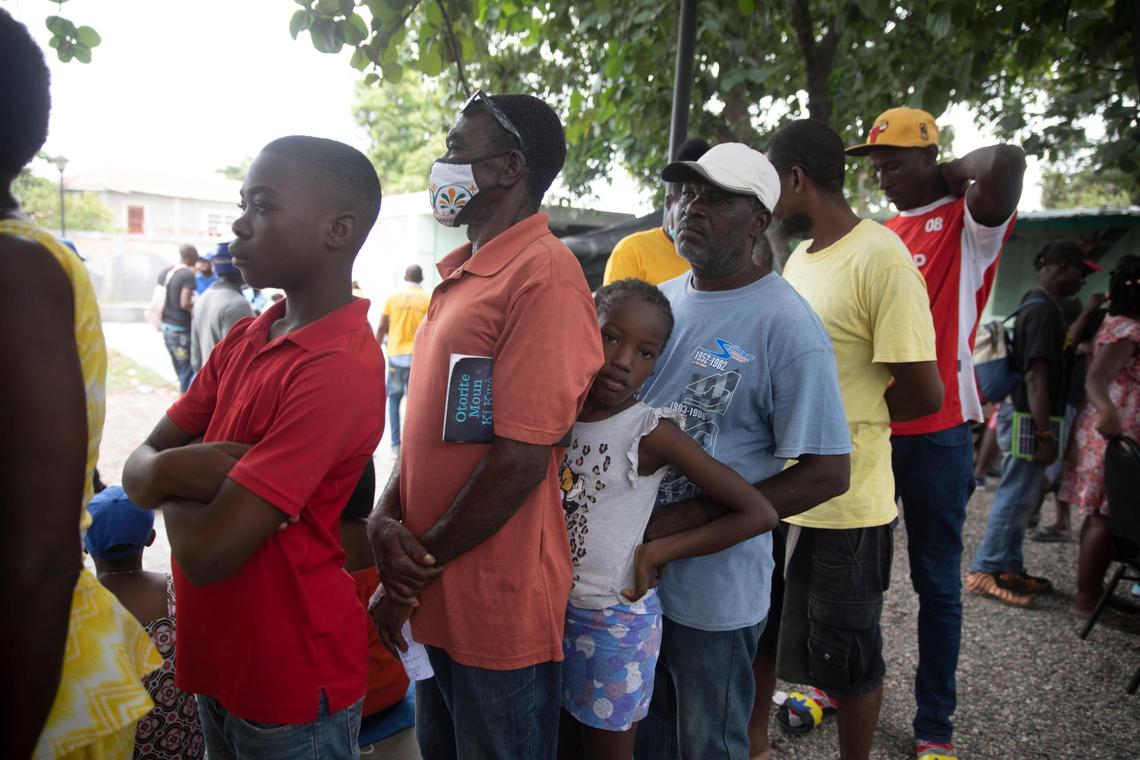 Residents who were displaced from their homes due to clashes between armed gangs in La Plaine stand in line as they wait to be examined at a mobile medical clinic in the Tabare neighborhood of Port-au-Prince, Haiti, Friday, May 13, 2022. Gang violence has forced dozens of schools and businesses to close in recent weeks and displaced thousands of families, with many of them seeking temporary shelter in schools and shelters.