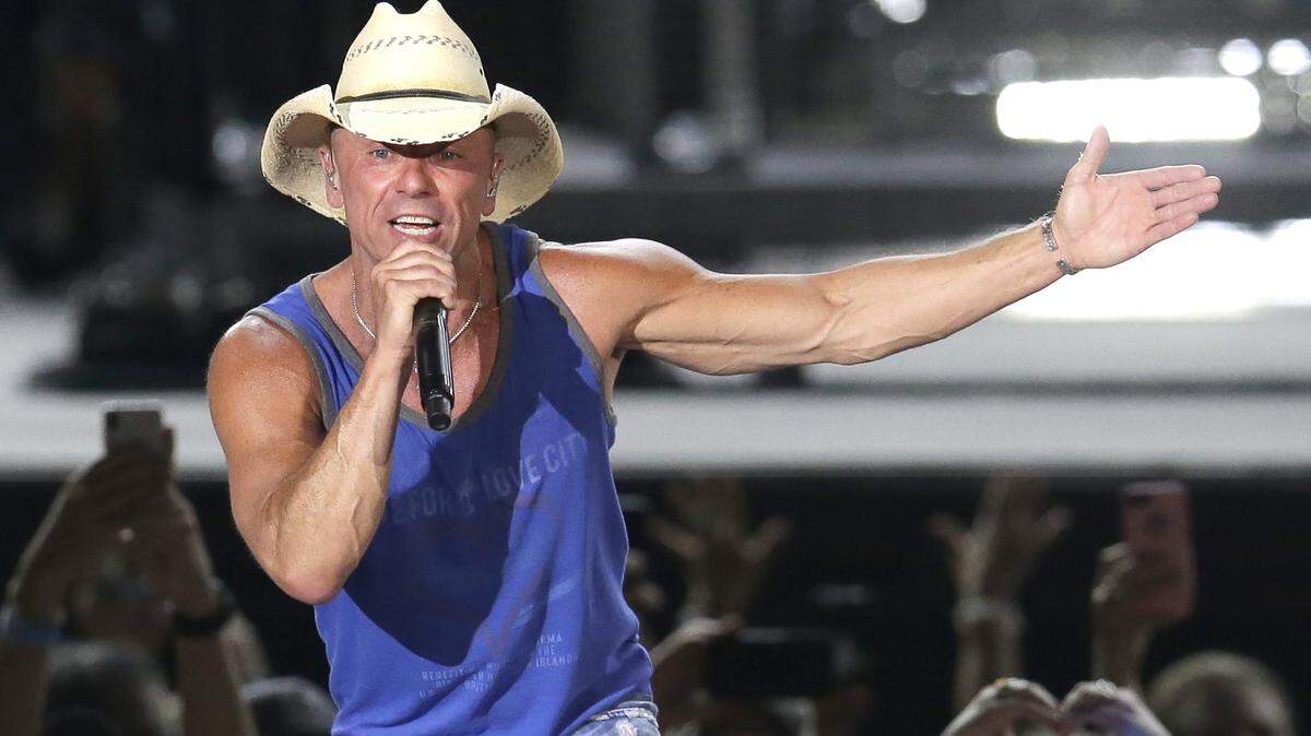In this June 23, 2018, file photo, Kenny Chesney performs during the Trip Around the Sun Tour in Phoenix. After Hurricane Irma decimated the U.S. Virgin Islands last year, Chesney started writing songs and organizing relief efforts. Chesney is donating proceeds from the sale of his new album, “Songs for the Saints,” to a foundation he set up to support recovery on the islands.