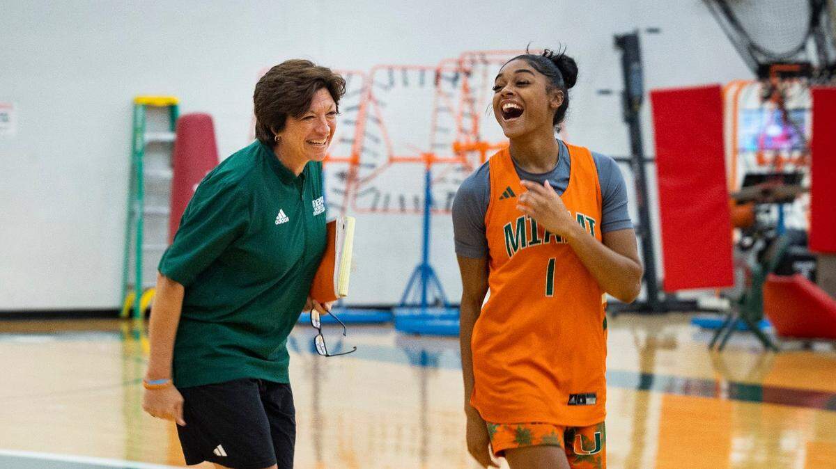 Head Coach Katie Meier jokes around with Lemyah Hilton (1) at the start of practice on Monday, Oct. 23, 2023, at the practice facility at Watsco Center in Coral Gables.