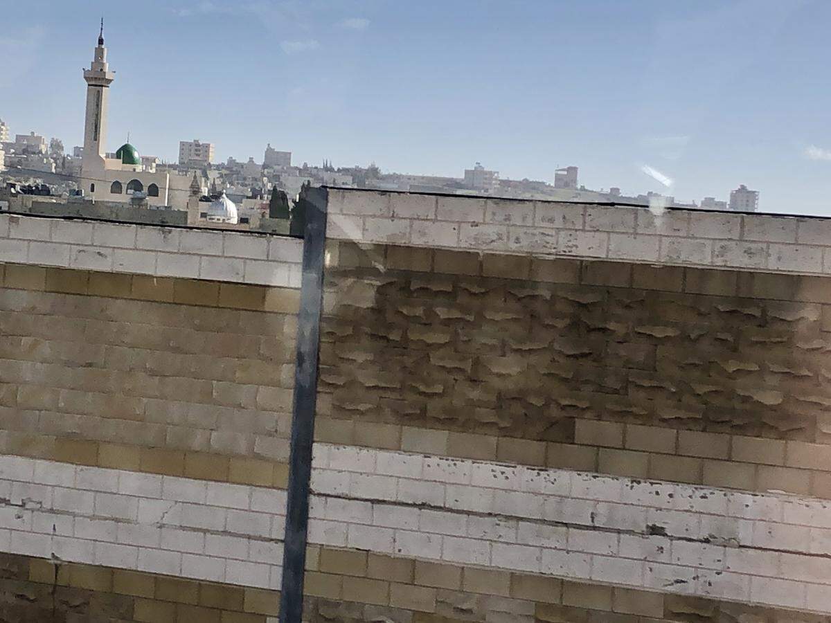 Old walls and new walls divide Israeli and Palestinian-held territories as you approach Jerusalem.