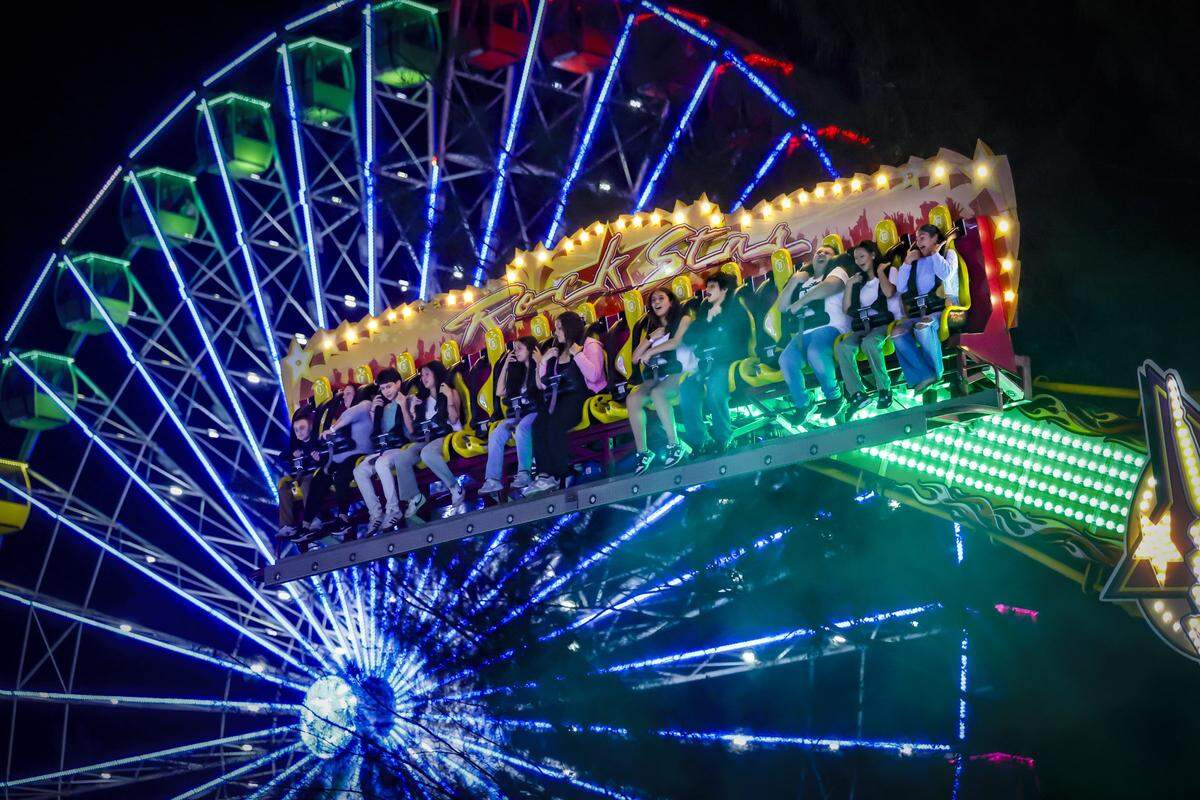 Visitors react while riding the Rock Star amusement ride at Christmas Wonderland at Tropical Park, a Miami-style holiday celebration of flavor and culture in Miami, Florida on Thursday, November 13, 2025.