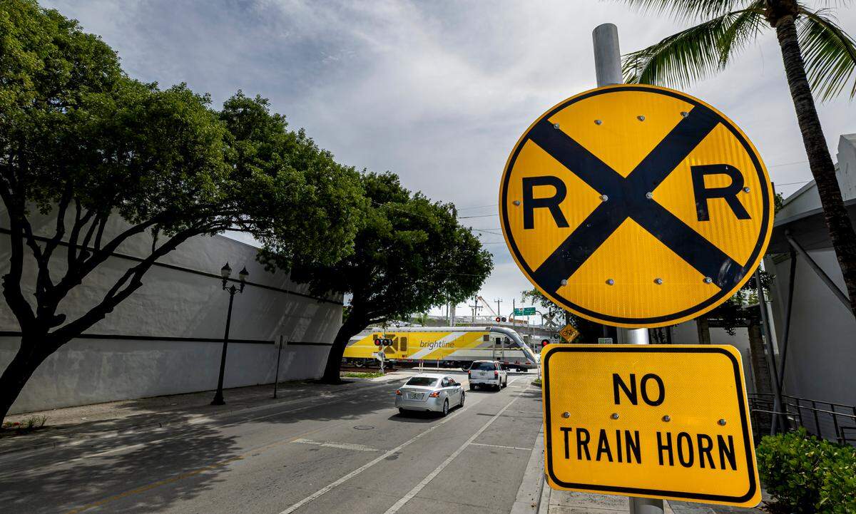 A ‘No Train Horn’ sign alerts drivers and pedestrians as a Brightline train crosses through Northwest 14th Street near Northwest 1st Avenue on Wednesday, July 9, 2025, in Miami, Fla.