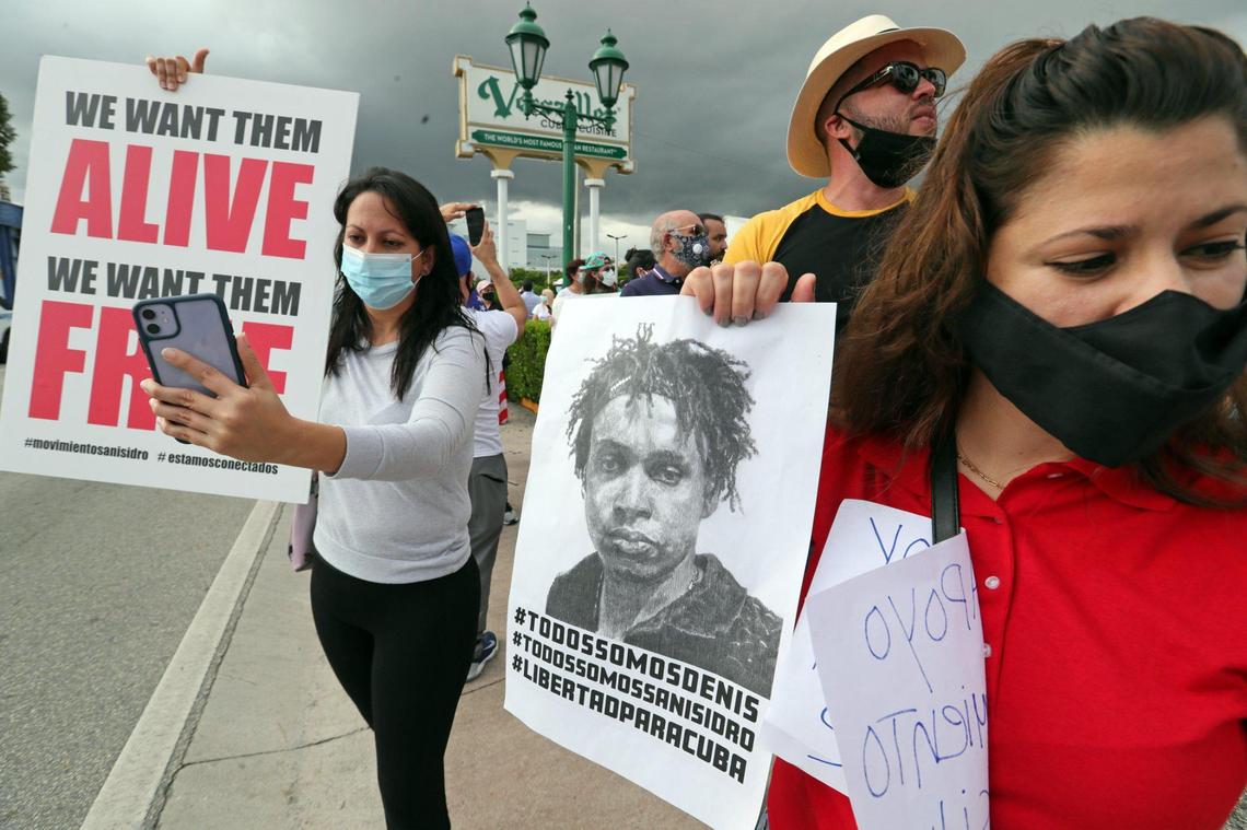 Grettel Perez holds a sign of an artist arrested in Cuba during an anti-Cuban government rally at Versailles Restaurant in Miami in support of Cuban artists arrested in Cuba on Saturday, November 28, 2020.