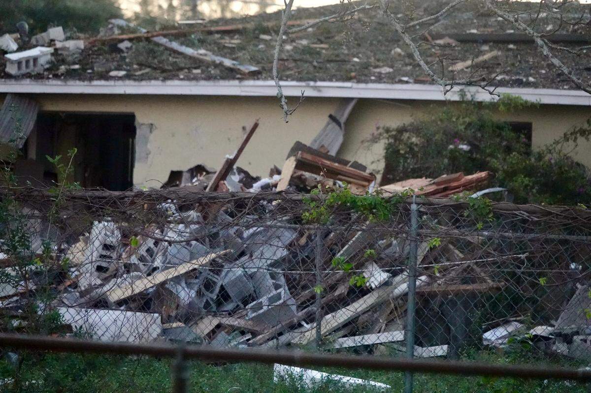 Firefighters investigate a house explosion in West Park, Florida, on Tuesday, Dec. 19, 2023.