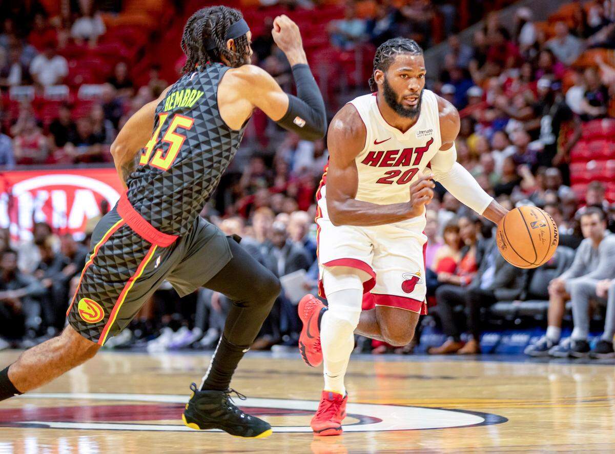 Heat guard/forward Justise Winslow (20) dribbles the ball as he is guarded by Hawks forward DeAndre’ Bembry (95) during the first quarter of a basketball game against Atlanta at AmericanAirlines Arena on Oct. 14, 2019.