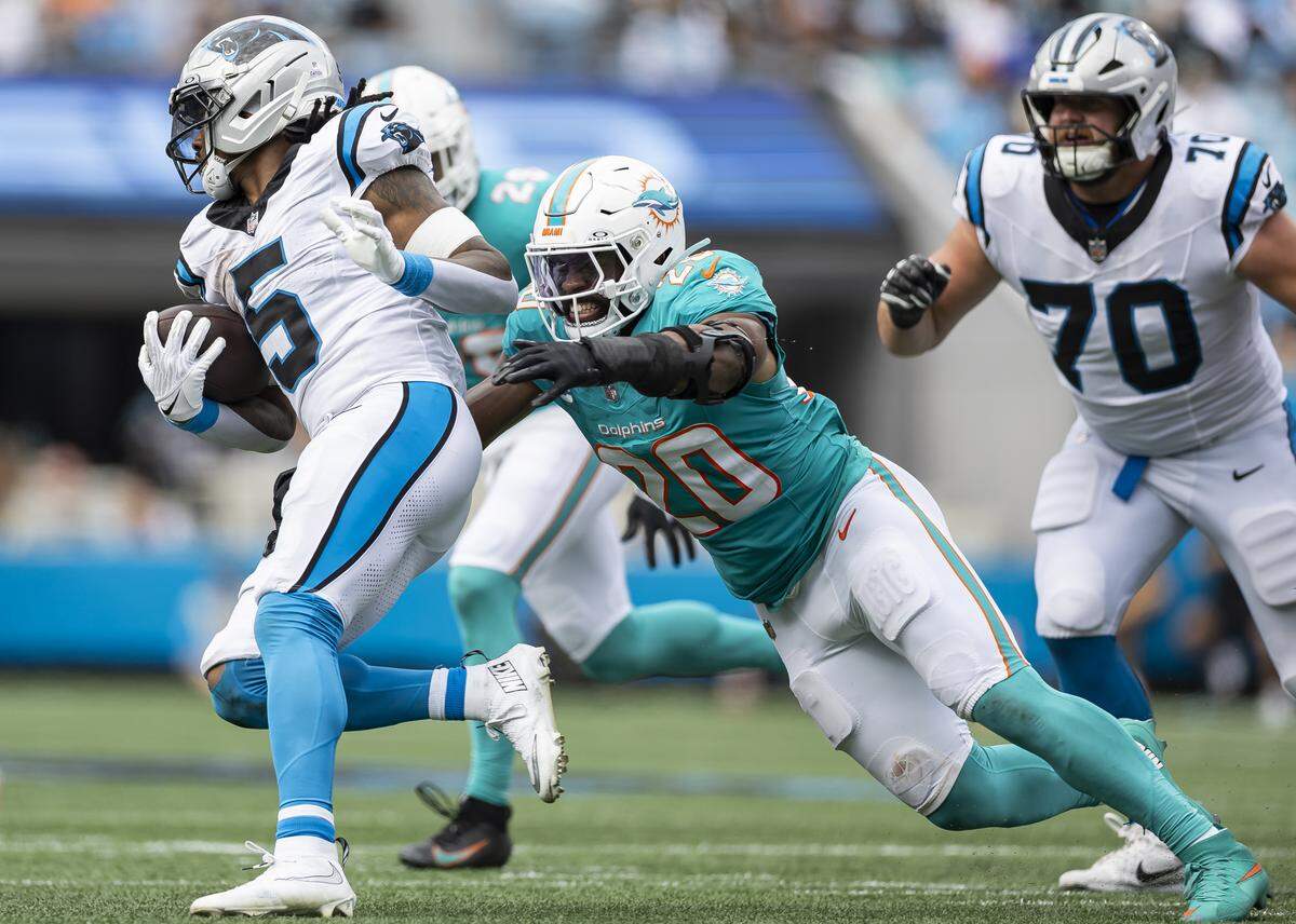 Miami Dolphins linebacker Jordyn Brooks (20) tackles Carolina Panthers running back Rico Dowdle (5) in the second half of their NFL game at the Bank of America Stadium on Sunday, Oct. 5, 2025, in Charlotte, N.C.