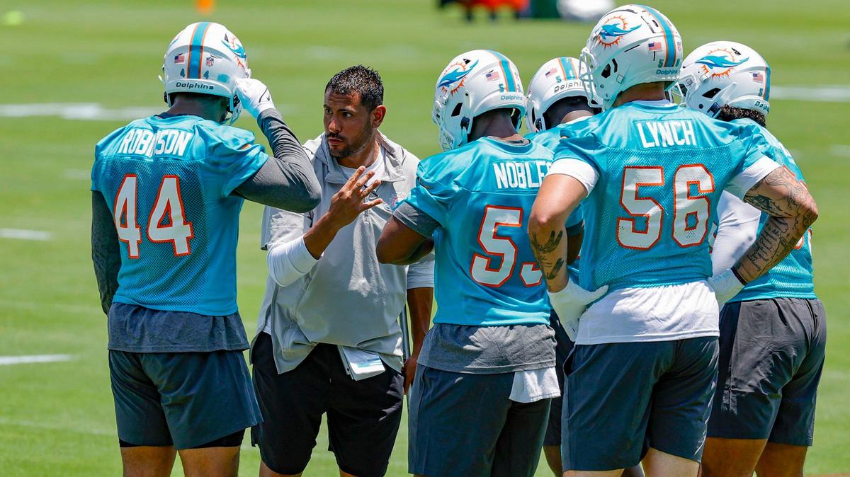 Miami Dolphins outside linebackers coach Ryan Crow speaks with linebacker Chop Robinson (44) and fellow players during practice.