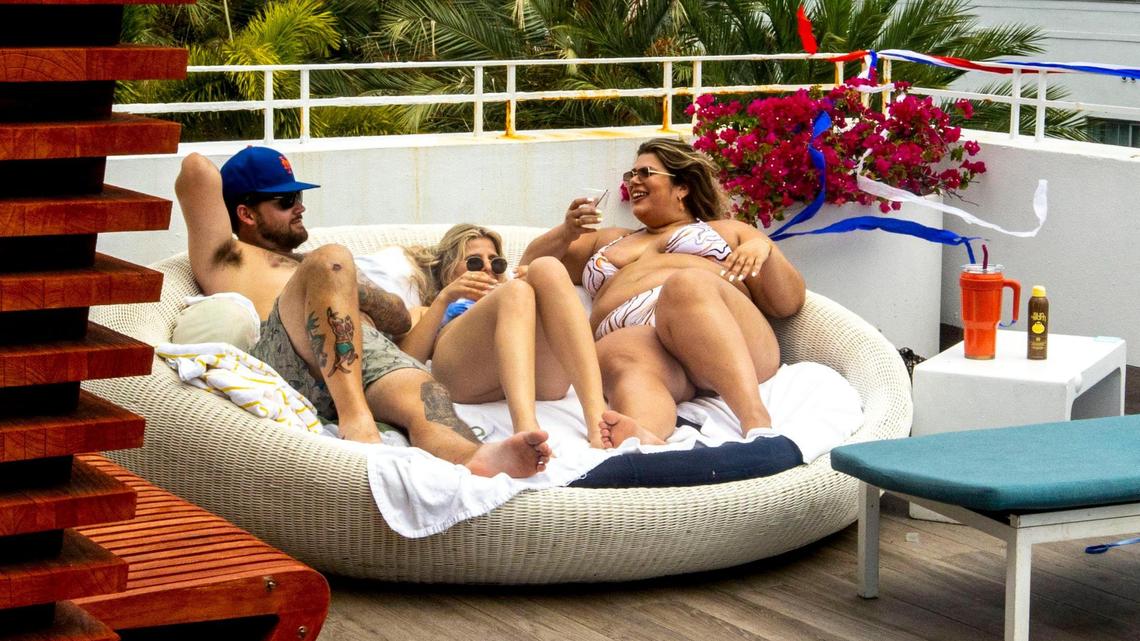 Hotel guests Austin Jones, 25, left, Emily Jansson, 26, center, and Dani Crepeau, 26, lounge by the pool at The Dream Hotel South Beach in Miami Beach, Florida, on Thursday, May 26, 2022.