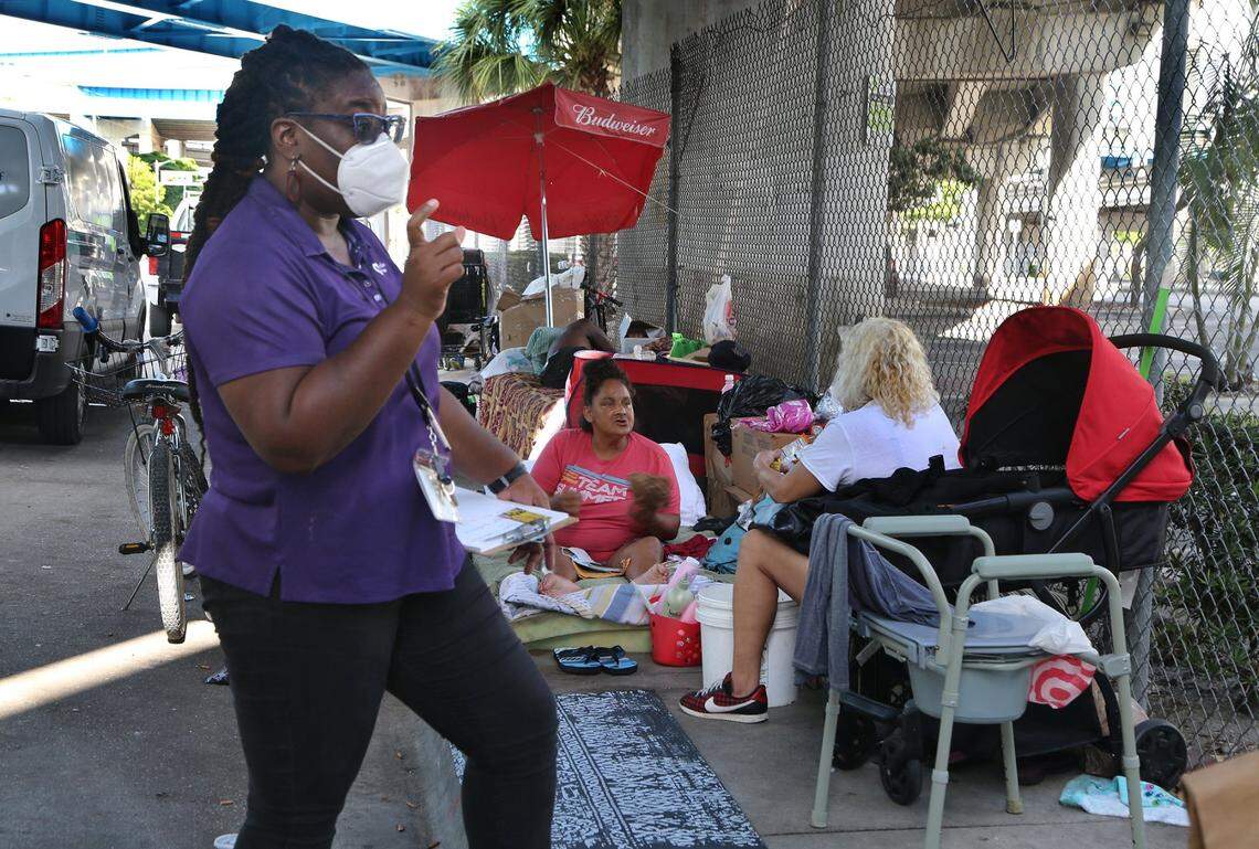 Camillus House staff manager Clarrissa Hazel brings medicines to a group of homeless people living in the streets of downtown Miami. Advocates are working to help prevent the spread of COVID-19.