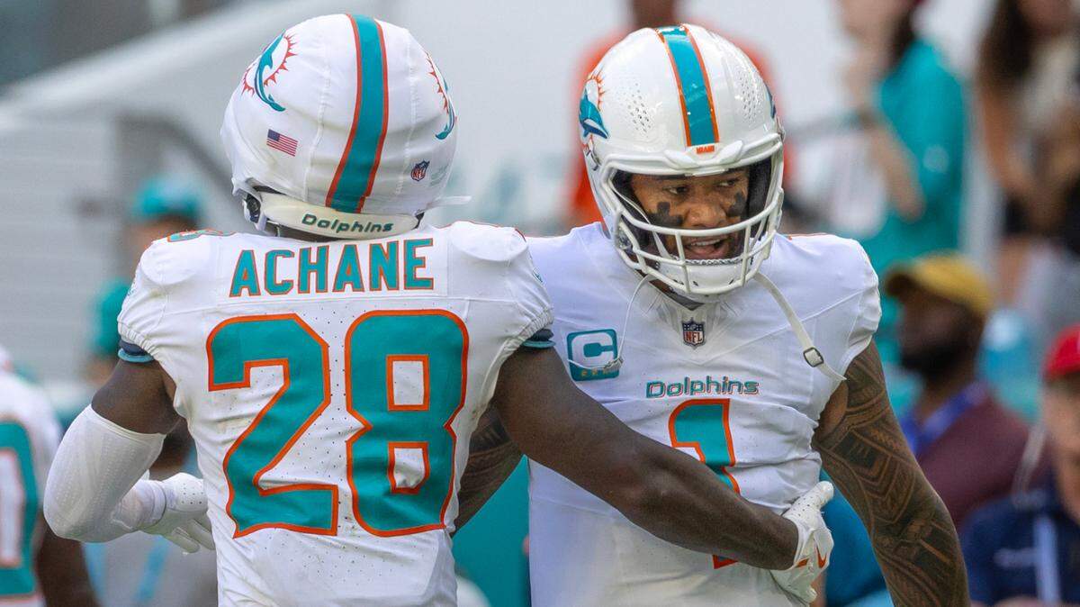 Miami Dolphins running back De’Von Achane (28) celebrates withDolphins quarterback Tua Tagovailoa after scoring a touchdown during the second half of an NFL game against the Arizona Cardinals at Hard Rock Stadium on Sunday, Oct. 27, 2024, in Miami Gardens, Fla.
