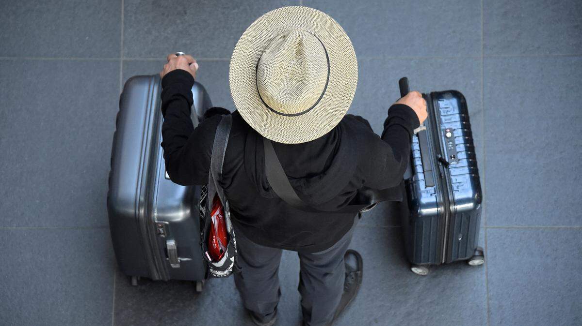 A train passenger with suitcases stands at Berlin’s Hauptbahnhof main railway station on August 11, 2021, as train drivers stage a strike.