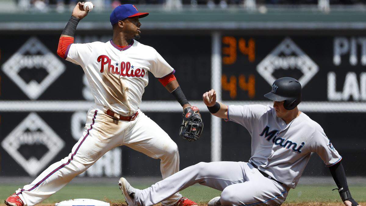Philadelphia Phillies shortstop Jean Segura, left, throws to first base after forcing out Miami Marlins’ Brian Anderson at second on a double play during the fourth inning of a baseball game, Sunday, April 28, 2019, in Philadelphia. Starlin Castro was out at first on the play. (AP Photo/Matt Slocum)