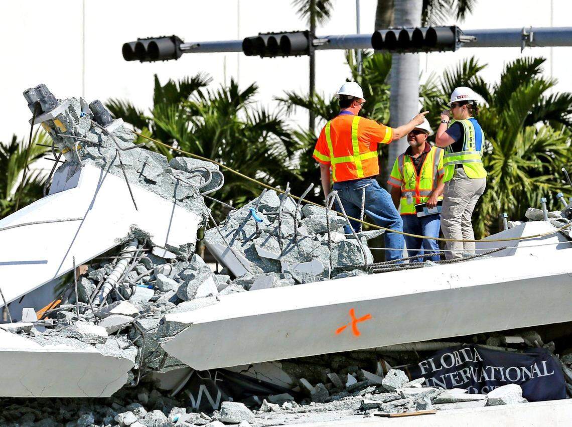 National Transportation Safety Board inspectors stand along a section of the FIU bridge on March 16, 2018, the day after it collapsed. The NTSB faulted all parties involved in the project for failing to exercise due diligence in addressing “abnormal” cracks.