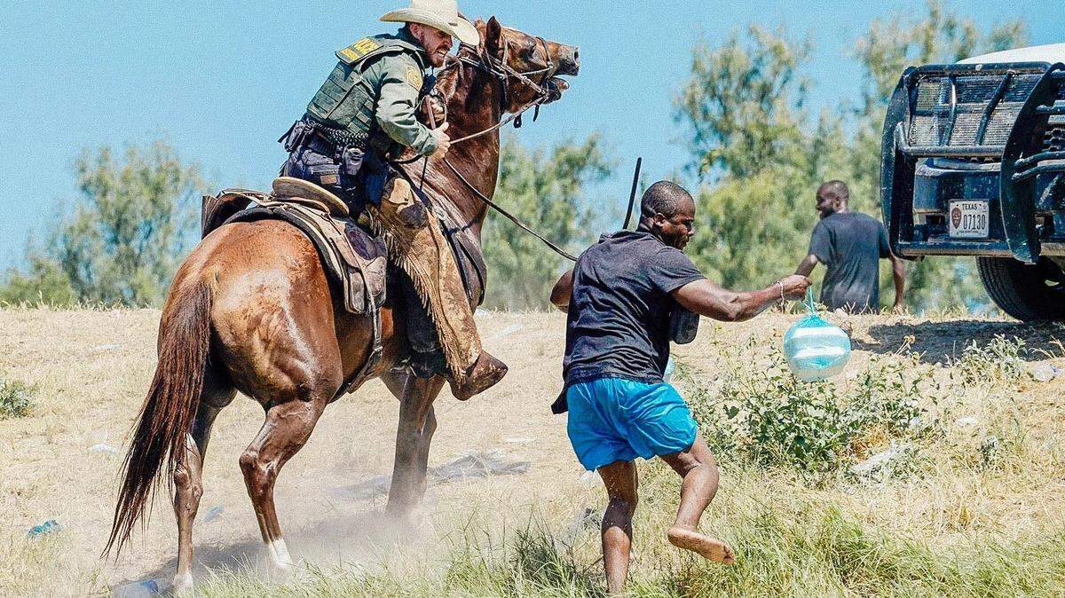 A U.S. Border Patrol agent on horseback uses the reins to try to stop a Haitian migrant from entering an encampment along the Rio Grande. Paul Ratje/AFP via Getty Images