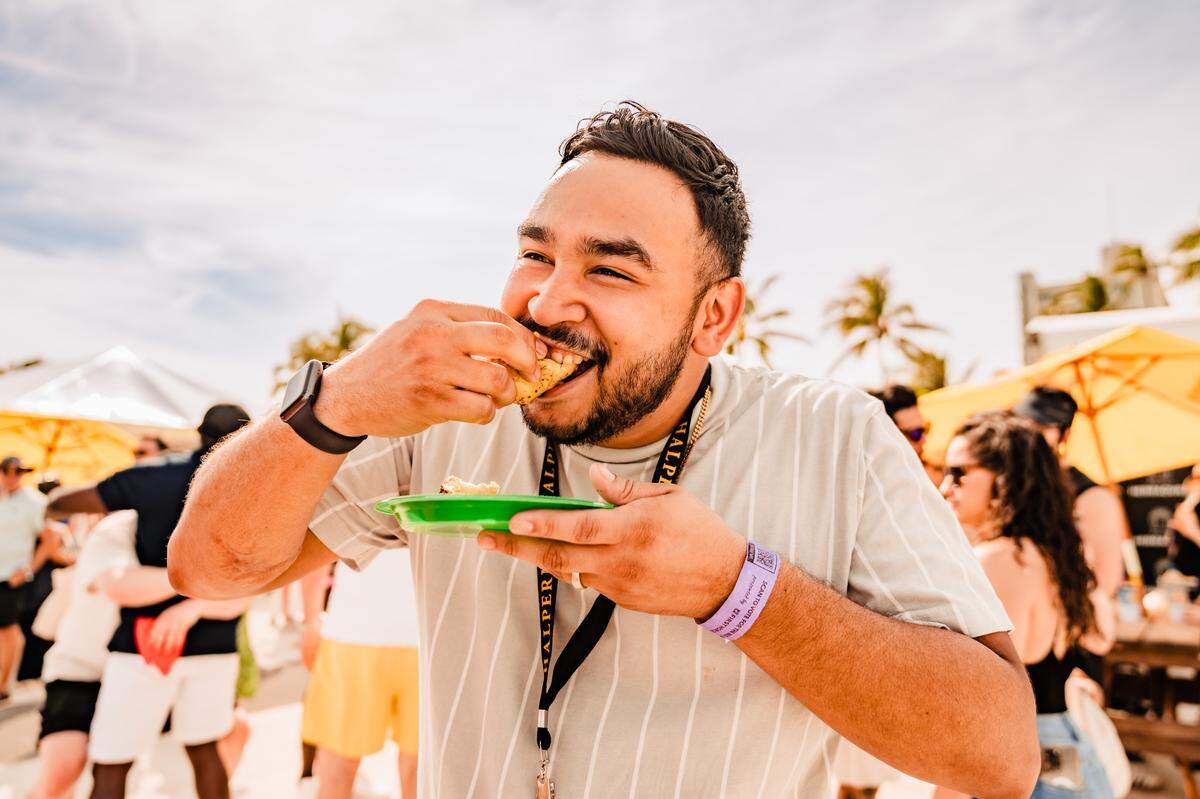 A guest at a previous South Beach Seafood Festival tries a seafood taco.