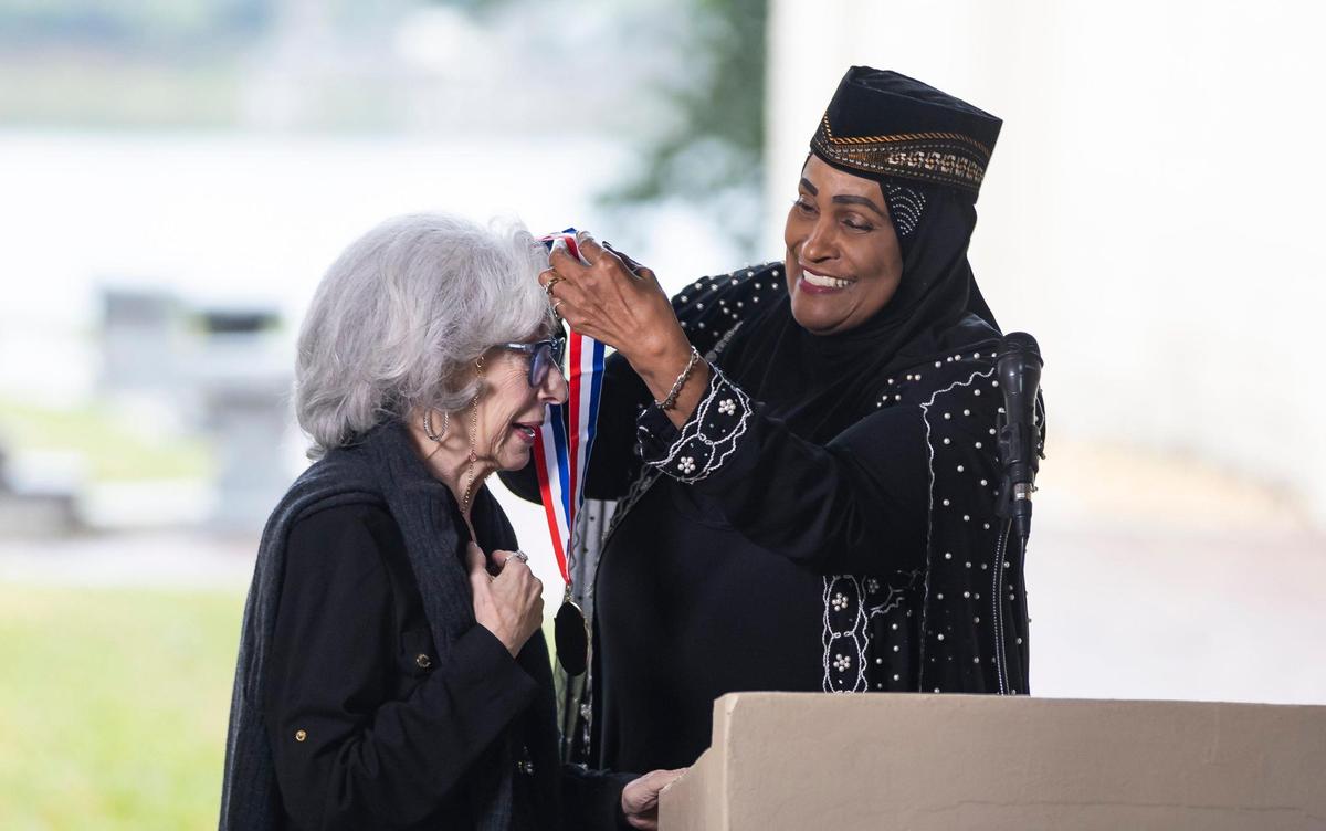 Khalilah Ali, former wife of Muhammad Ali, presents Joyce Moore, widow of the late Sam Moore, with the Presidential Lifetime Achievement Award during his funeral service at Lakeside Memorial Park and Funeral Home on Friday, Jan. 17, 2025, in Doral, Fla. Moore, the R&B singer from the famed 1960s duo Sam & Dave, died on Friday, Jan. 10, at the age of 89.